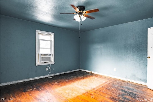 empty room with hardwood / wood-style flooring, ceiling fan, and cooling unit