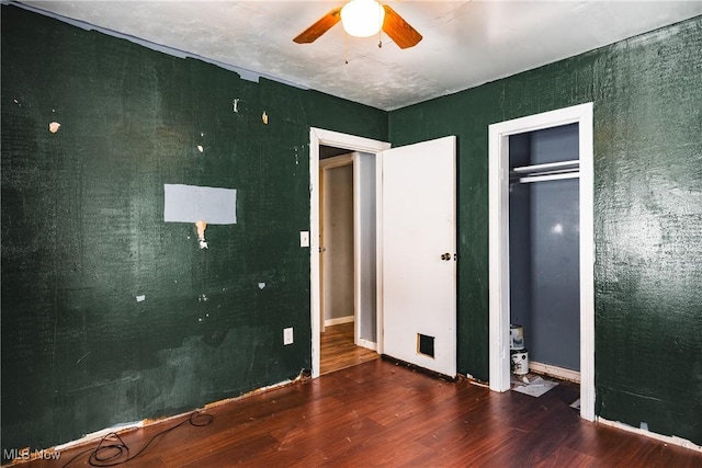 unfurnished bedroom with ceiling fan, dark hardwood / wood-style flooring, and a closet