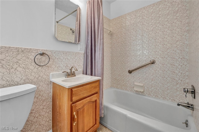 full bathroom featuring tile walls, toilet, vanity, and shower / bath combo