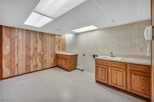 bathroom featuring vanity, a drop ceiling, and wooden walls