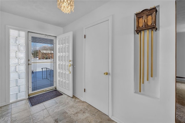 foyer entrance with a notable chandelier