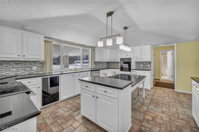 kitchen with tasteful backsplash, dishwasher, a center island, white cabinetry, and hanging light fixtures