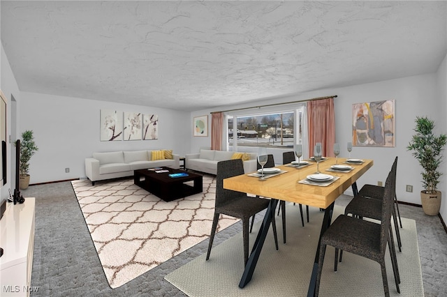 carpeted dining space featuring a textured ceiling