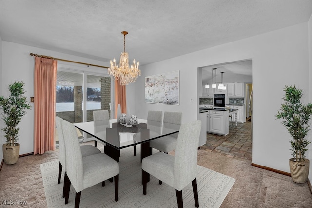 dining room with an inviting chandelier and a textured ceiling