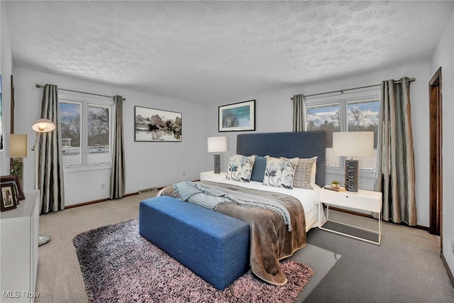 bedroom featuring light colored carpet and a textured ceiling