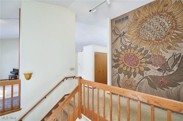 staircase featuring carpet flooring and rail lighting