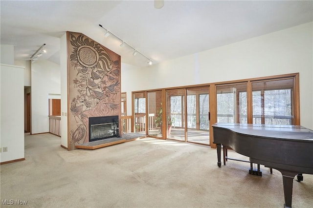 interior space with a fireplace, light colored carpet, and high vaulted ceiling