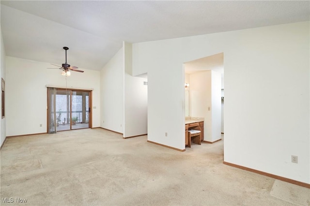 carpeted spare room featuring lofted ceiling and ceiling fan