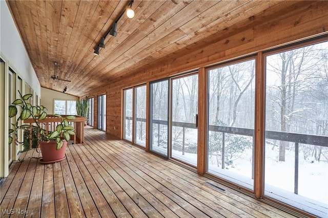 unfurnished sunroom featuring track lighting, wooden ceiling, lofted ceiling, and ceiling fan