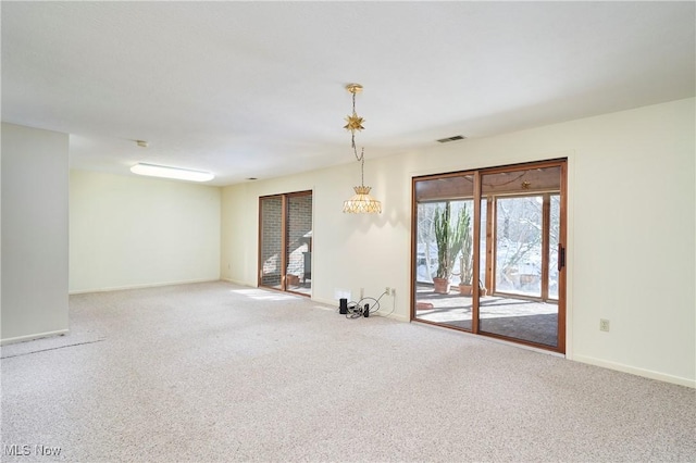 unfurnished room featuring carpet flooring and a notable chandelier