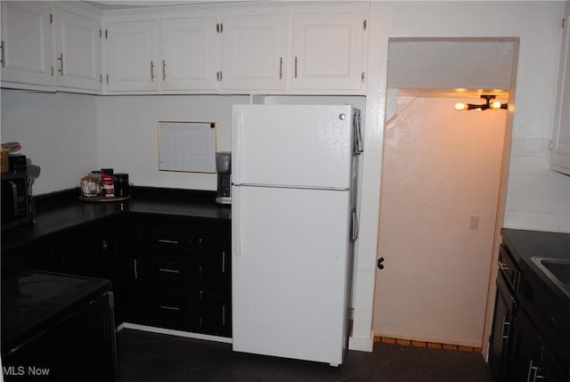 kitchen with white cabinets, white fridge, and black electric range