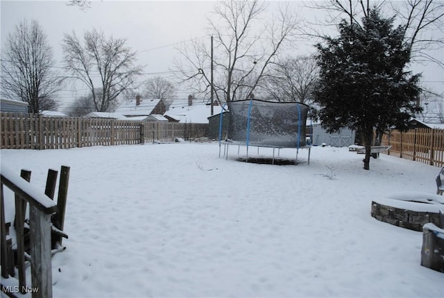 yard covered in snow featuring a trampoline