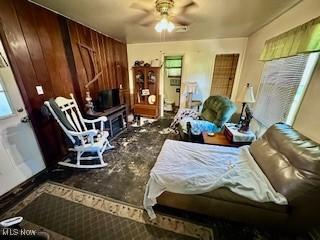 miscellaneous room with ceiling fan and wood walls