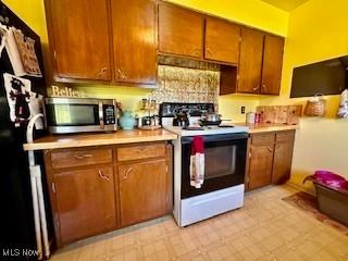 kitchen with black fridge and electric stove