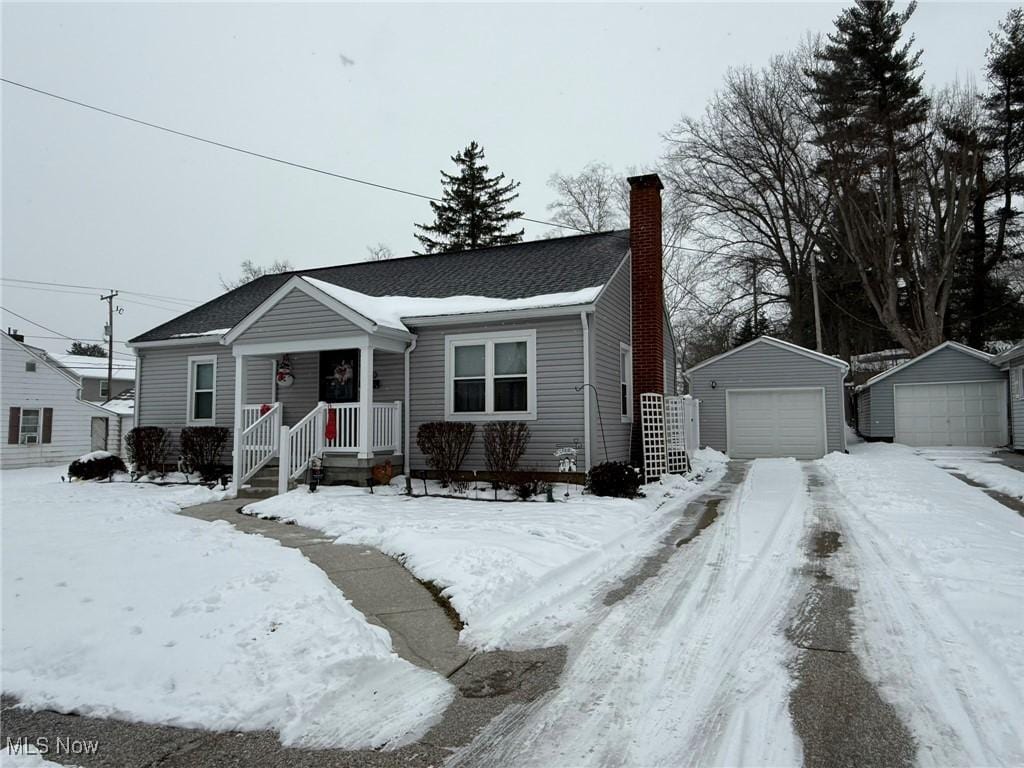 view of front of home with a garage and an outbuilding