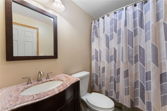 bathroom featuring toilet, vanity, and a shower with curtain