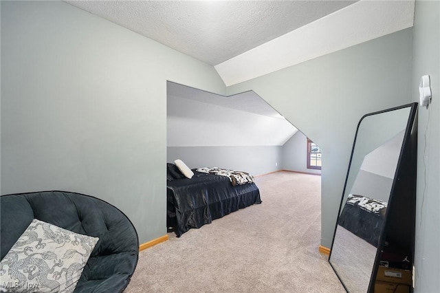 bedroom with a textured ceiling, vaulted ceiling, and carpet