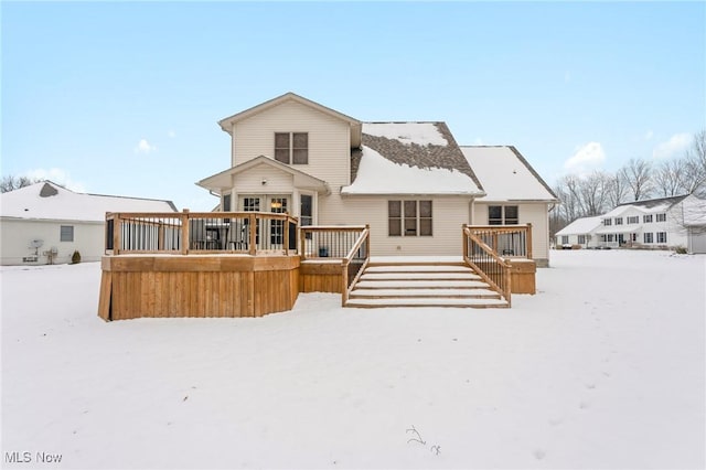 snow covered house featuring a wooden deck