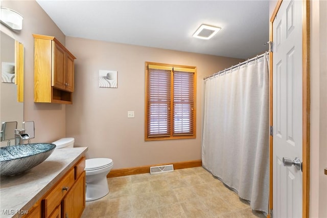 bathroom featuring toilet, curtained shower, and vanity