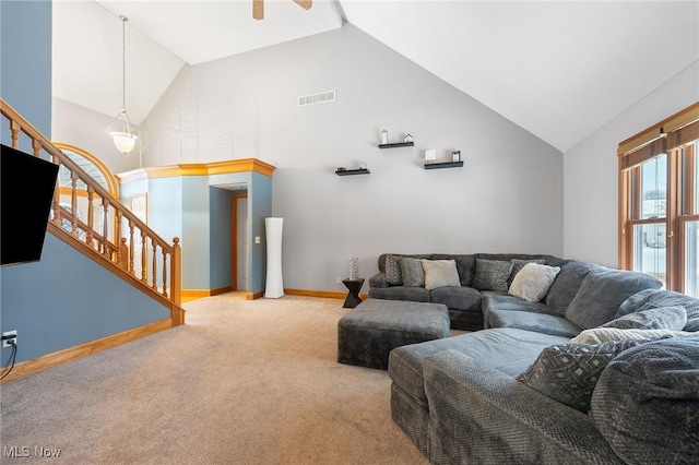 carpeted living room with high vaulted ceiling