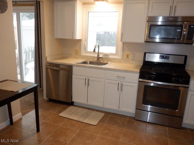 kitchen featuring sink, stainless steel appliances, white cabinetry, and plenty of natural light