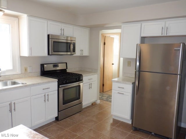 kitchen featuring white cabinets, appliances with stainless steel finishes, and sink