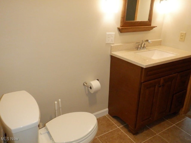 bathroom with tile patterned flooring, vanity, and toilet