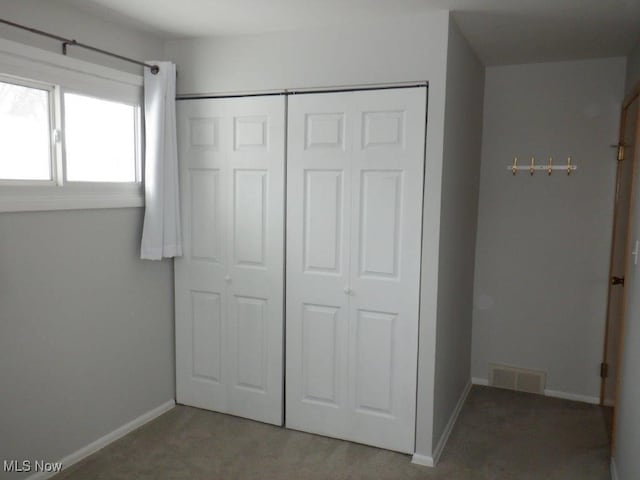 unfurnished bedroom with a closet and carpet floors