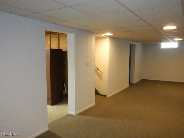 basement with a drop ceiling and carpet