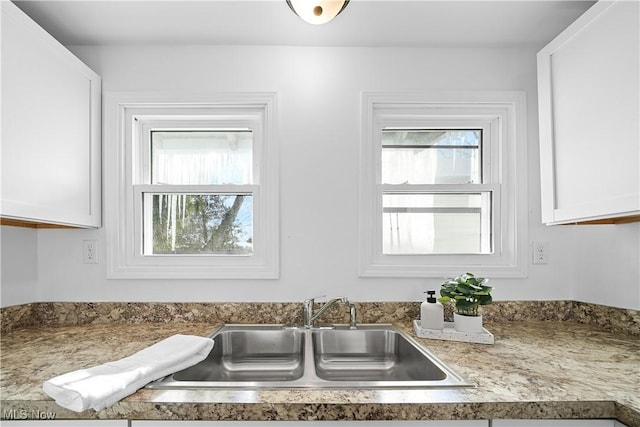 kitchen with white cabinets, a healthy amount of sunlight, and sink