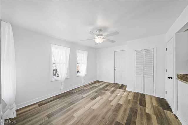 empty room with hardwood / wood-style floors and ceiling fan