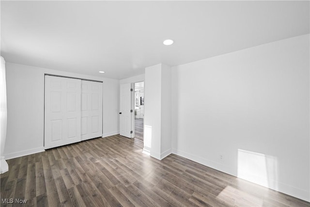 unfurnished bedroom with a closet and dark hardwood / wood-style floors