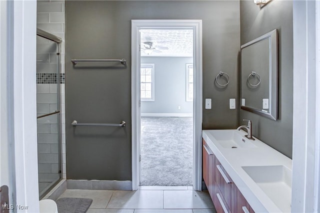 bathroom featuring ceiling fan, walk in shower, tile patterned flooring, and vanity