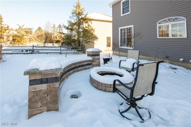 snow covered patio with a fire pit