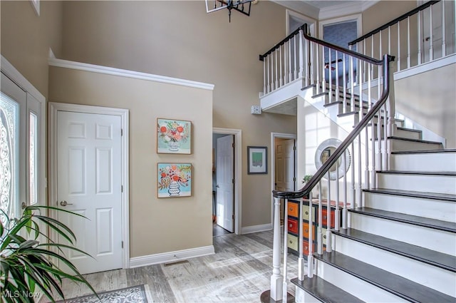 entryway with a high ceiling, an inviting chandelier, and light wood-type flooring