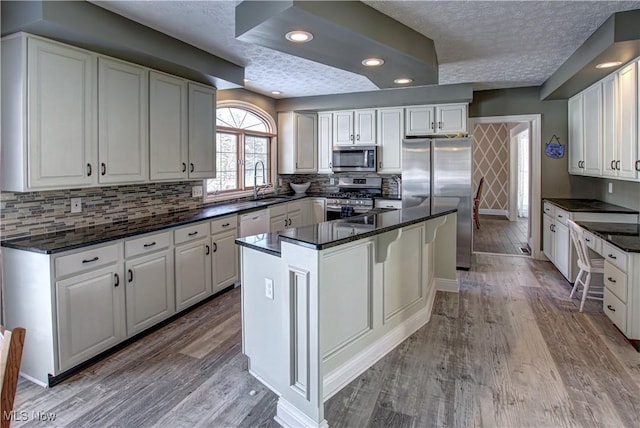 kitchen with stainless steel appliances, a center island, and white cabinetry