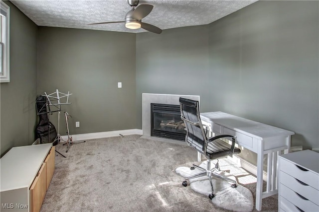 carpeted office featuring a textured ceiling and ceiling fan