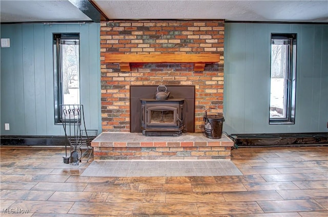 details featuring wooden walls, a textured ceiling, a wood stove, and hardwood / wood-style flooring