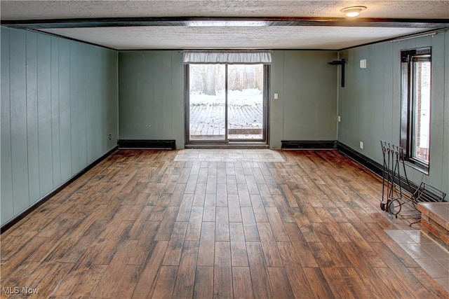 unfurnished room with hardwood / wood-style floors, a textured ceiling, and a healthy amount of sunlight