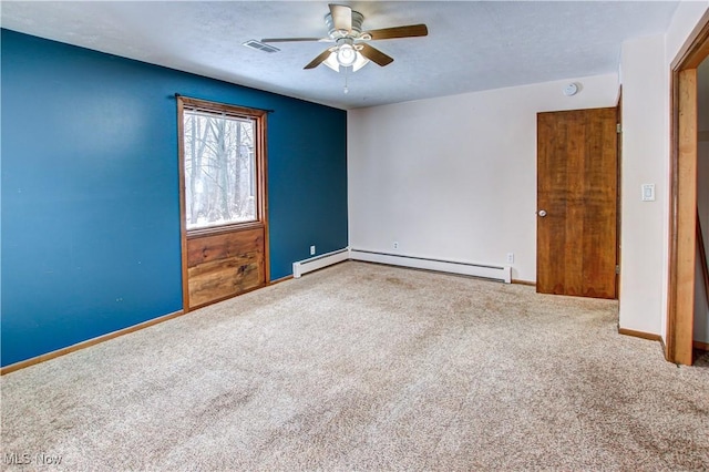 carpeted spare room featuring a baseboard heating unit and ceiling fan