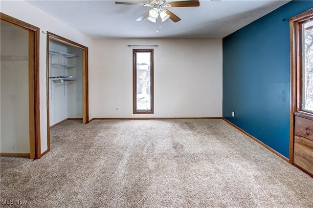 unfurnished bedroom with multiple windows, ceiling fan, and carpet