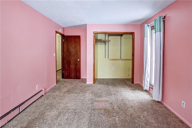 unfurnished bedroom with light carpet, a closet, and a baseboard heating unit