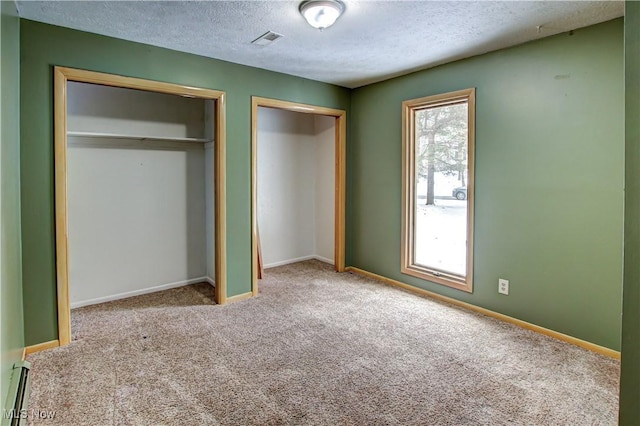 unfurnished bedroom featuring a closet, a baseboard radiator, carpet floors, and a textured ceiling