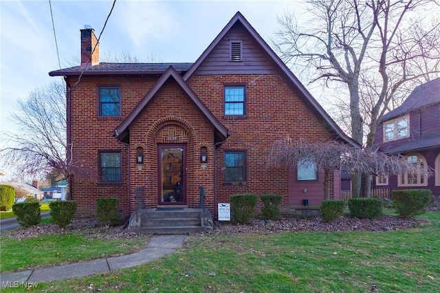 tudor-style house with a front lawn