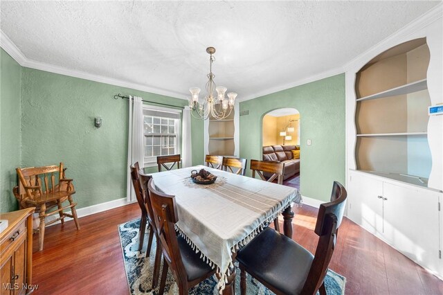 dining space featuring a notable chandelier, ornamental molding, dark hardwood / wood-style floors, a textured ceiling, and built in features