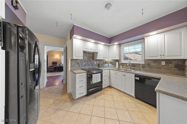 kitchen featuring black appliances, white cabinetry, decorative backsplash, and sink