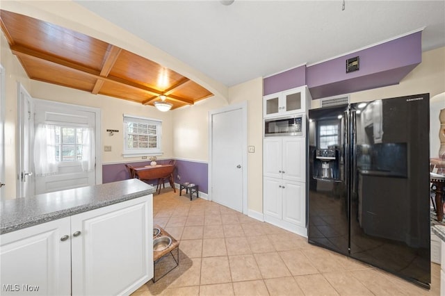 kitchen with light tile patterned floors, white cabinetry, beam ceiling, coffered ceiling, and black fridge with ice dispenser