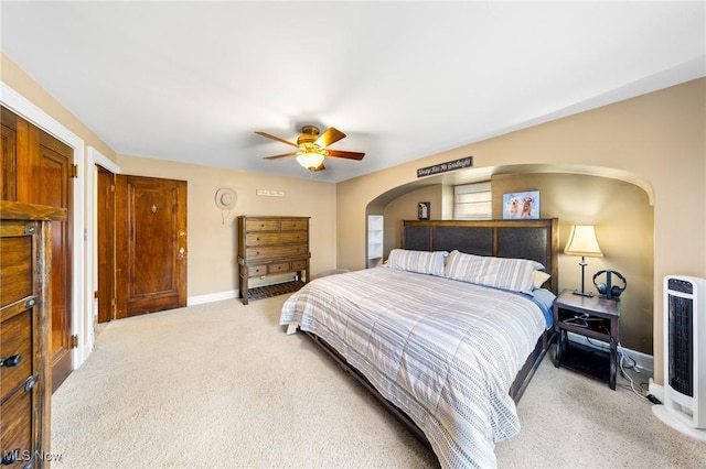 carpeted bedroom with ceiling fan and heating unit