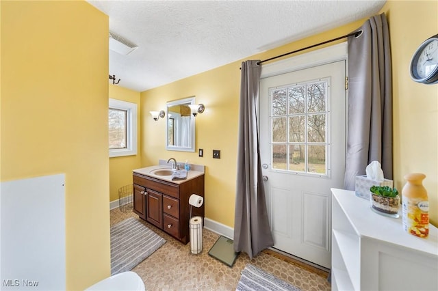 bathroom with a textured ceiling and vanity