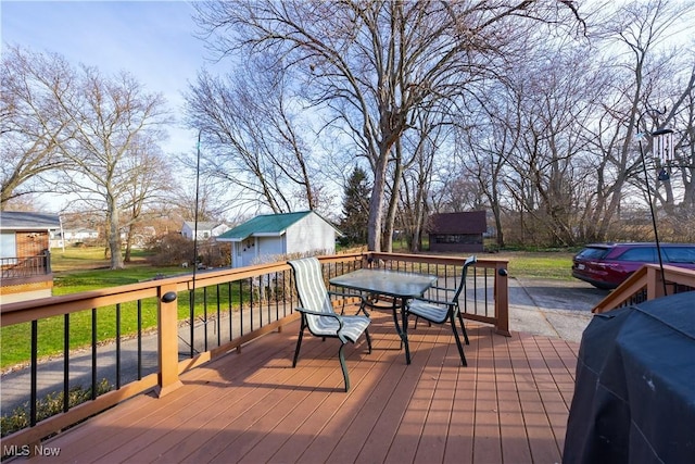 wooden deck featuring area for grilling and an outdoor structure